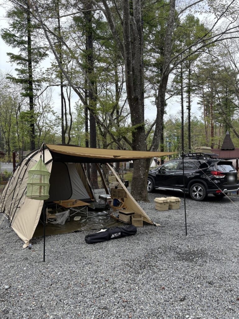チョイ広めオートキャンプサイトに張った2ルームテントとタープ、奥に停めた車