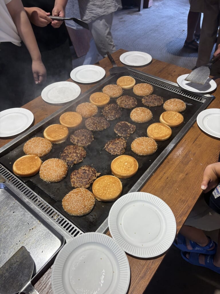 ハンバーガー作りで鉄板に並んだパティとバンズ