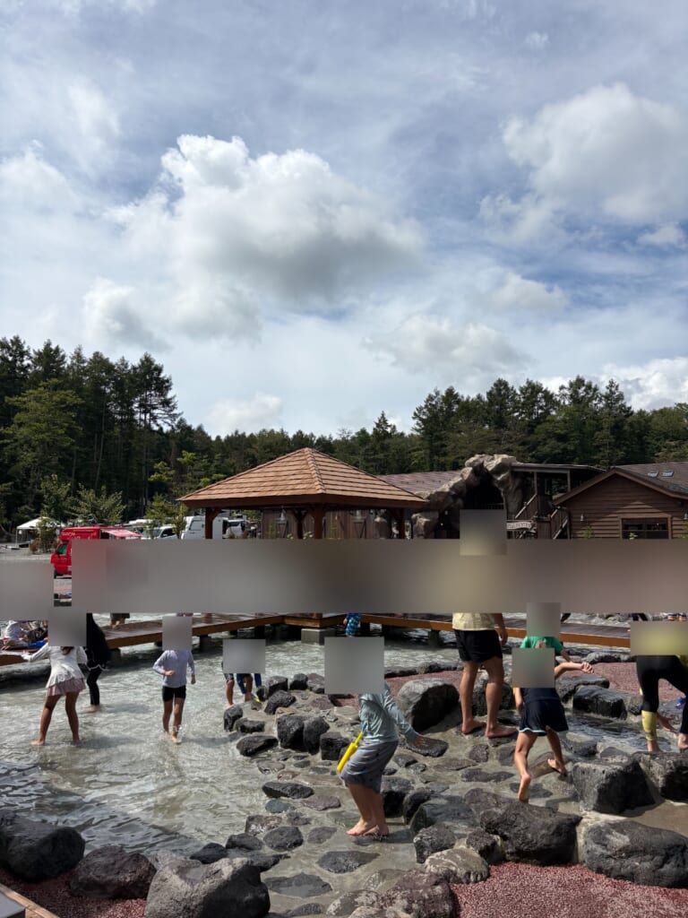じゃぶじゃぶ池で水遊びをする子どもたち。奥にキッチンカー